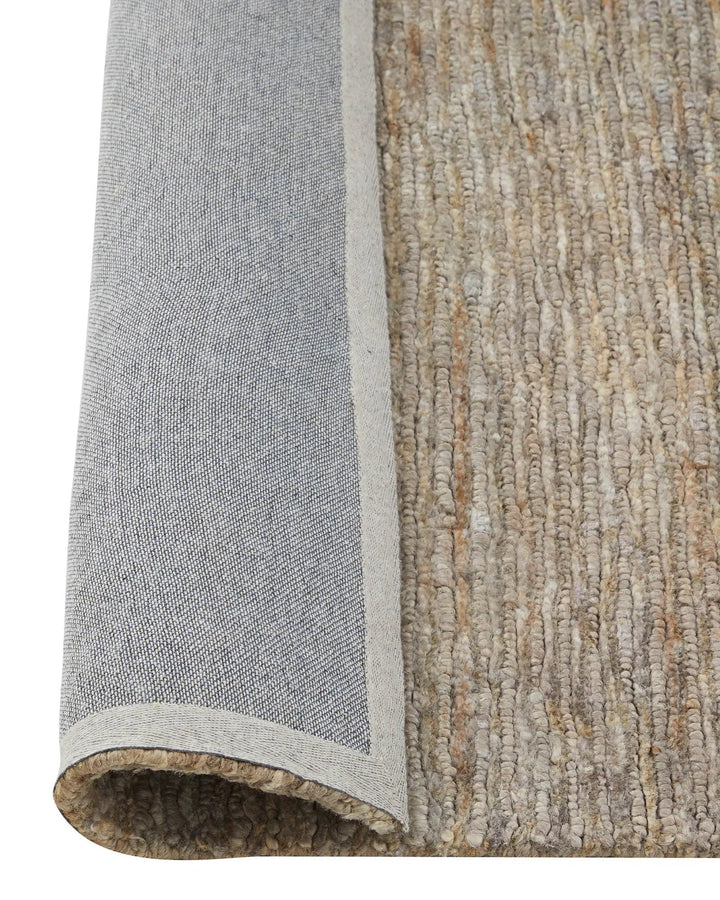 Close-up of a textured rug with a border transitioning from gray to beige.