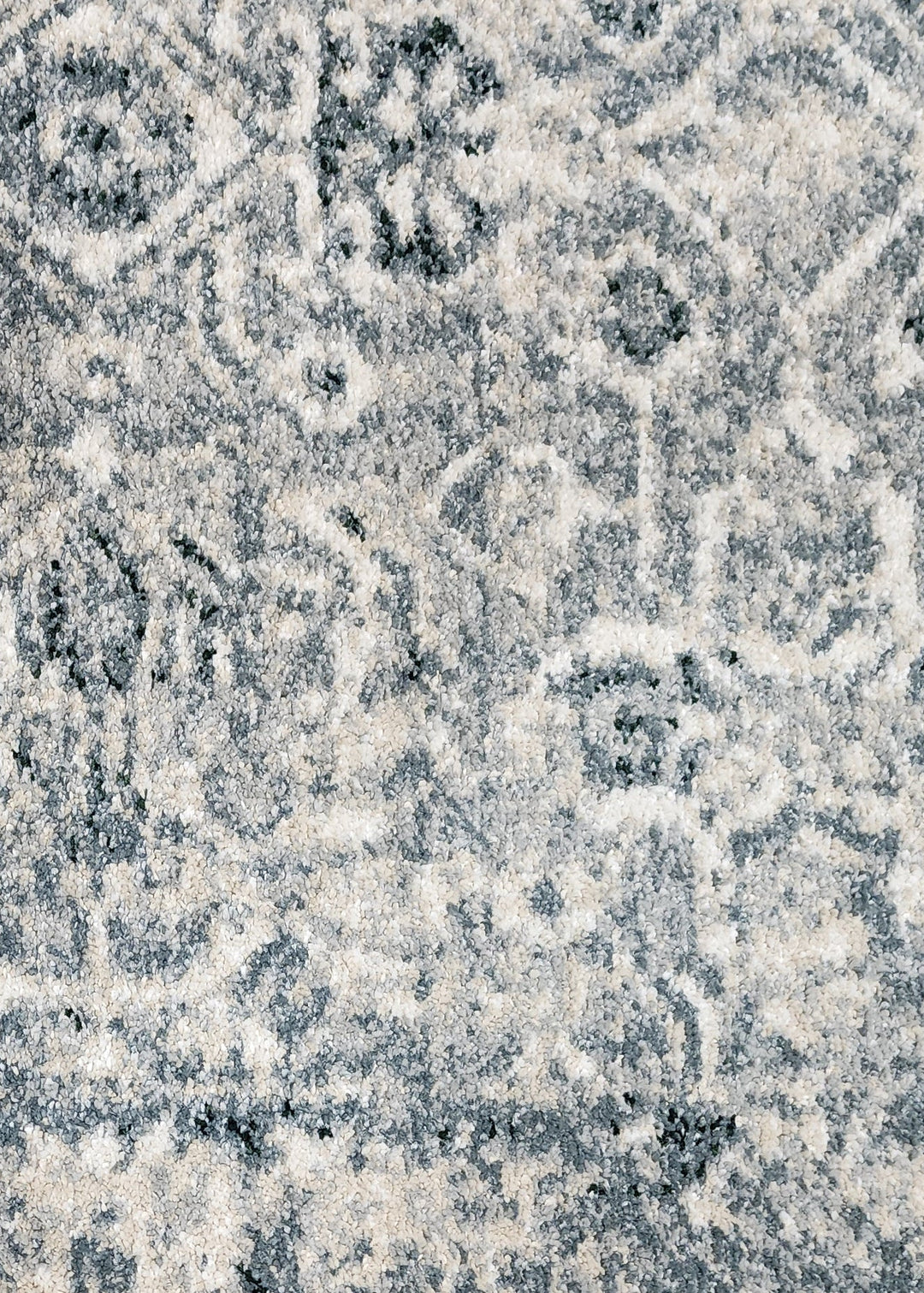 Close-up of a textured seafoam blue and white rug with intricate patterns.