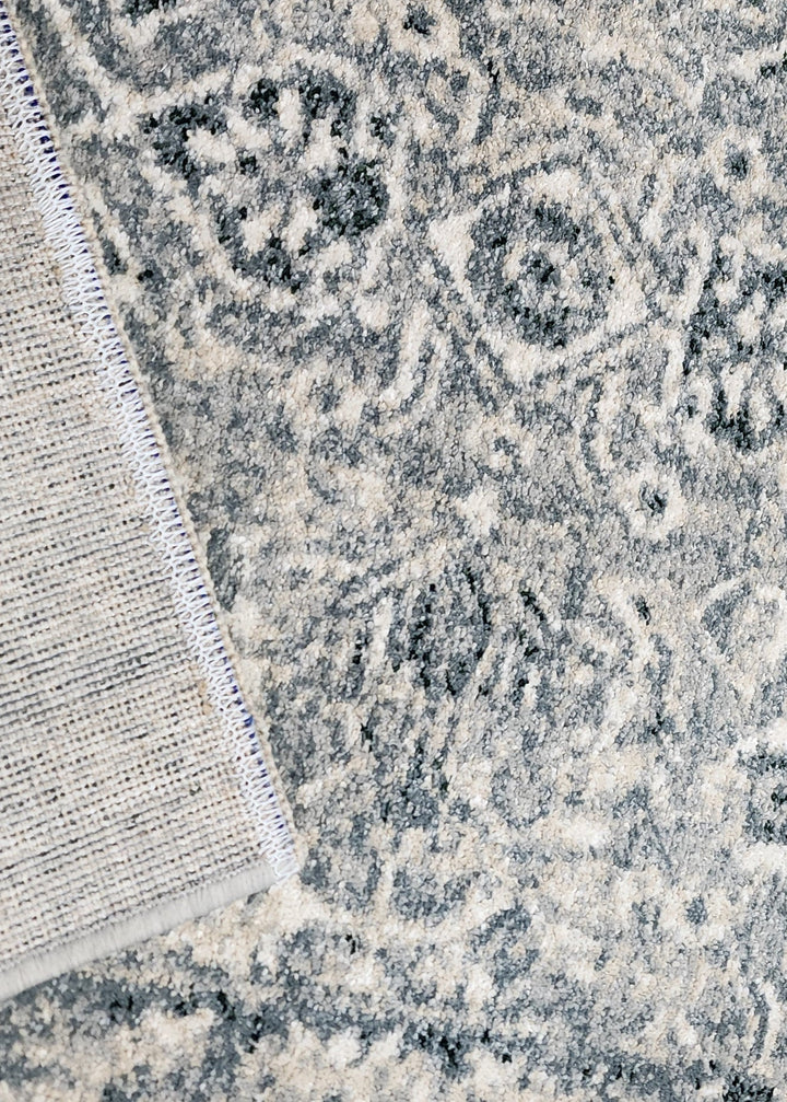 Close-up of a textured rug with intricate patterns and a neutral color palette.