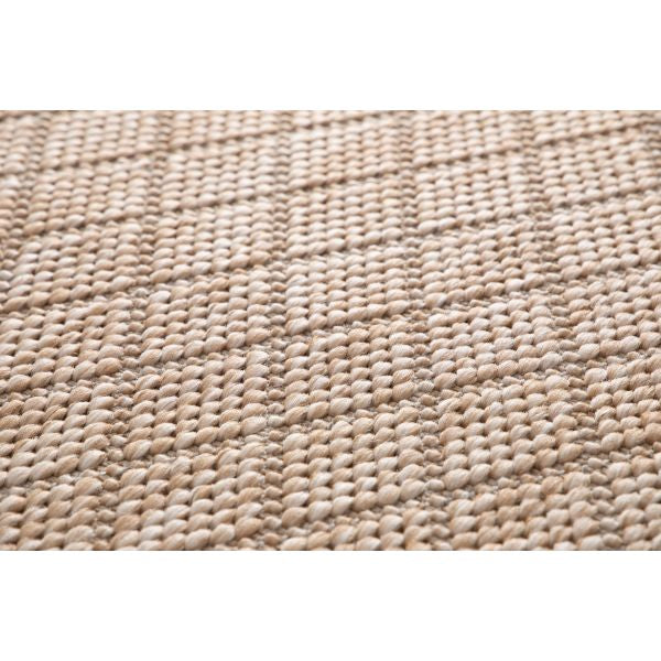 Close-up of a textured beige rug with a woven pattern.