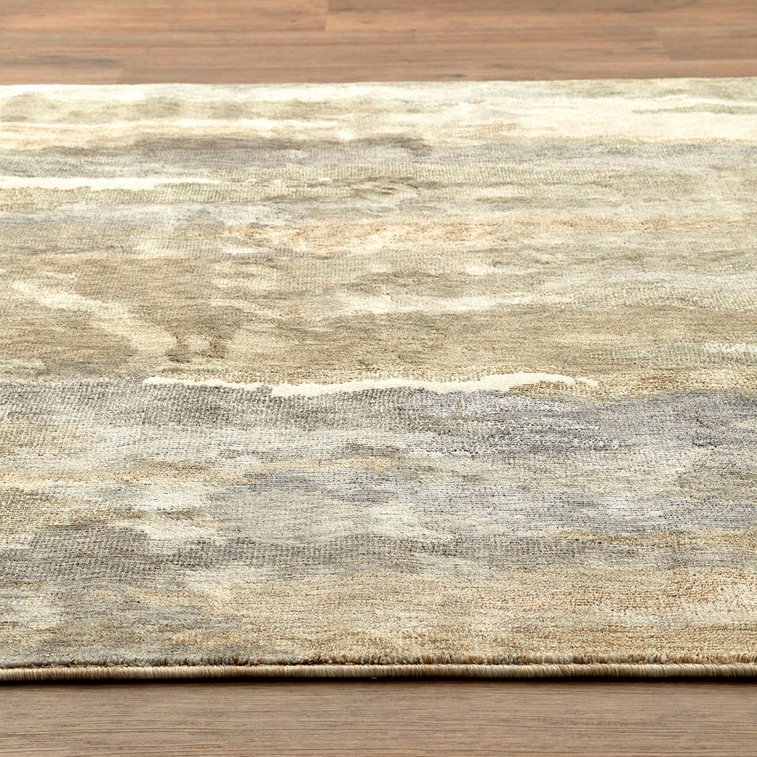 Textured rug with a neutral color palette on a wooden floor.