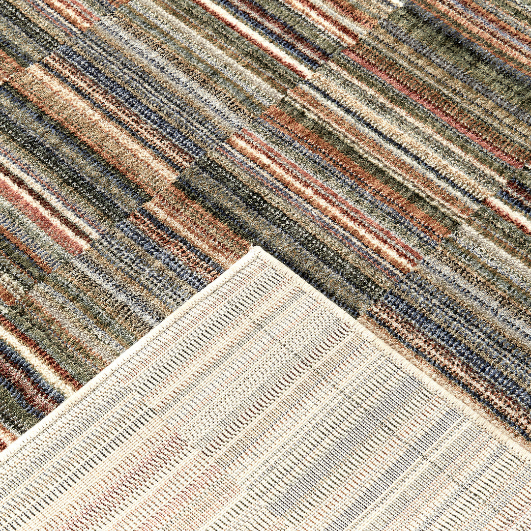 Close-up of a multicolored striped rug with a geometric pattern.