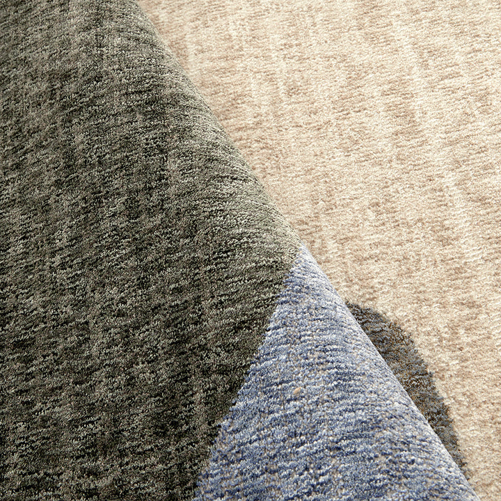 Close-up of textured fabric in green, beige, and blue.