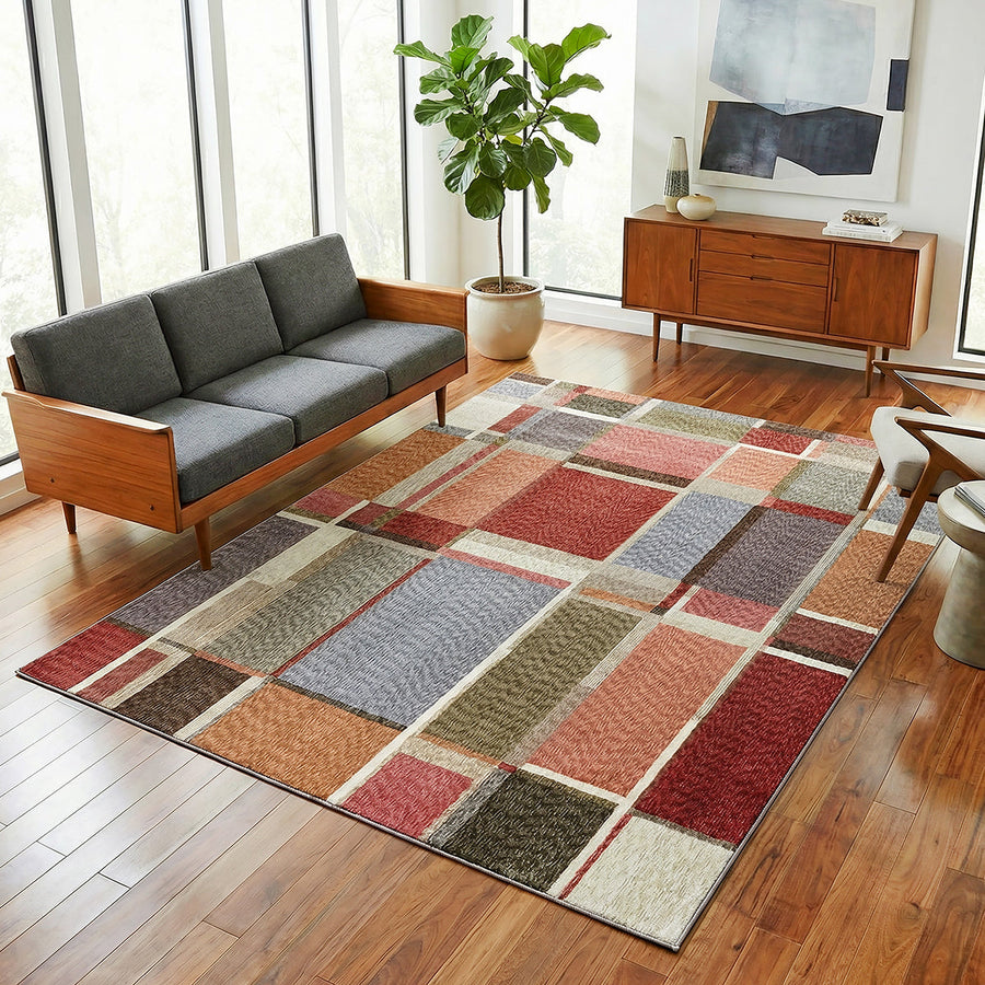 Multicolored checkered rug on a wooden floor with a sofa and sideboard in the background.