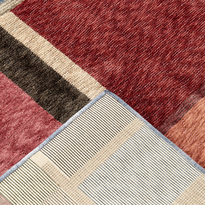 Close-up of a multicolored checkered rug with red, brown, beige, and gray patterns.