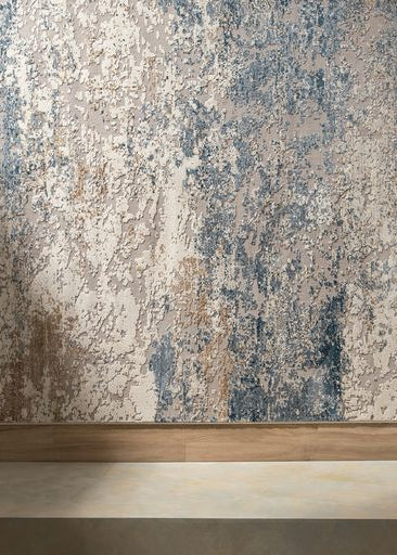 Textured rug with a industrial blue colour palette and a wooden floor baseboard.
