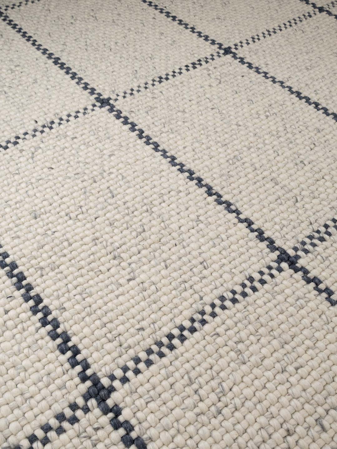 Close-up of a textured fabric with a diamond pattern in gray and black.