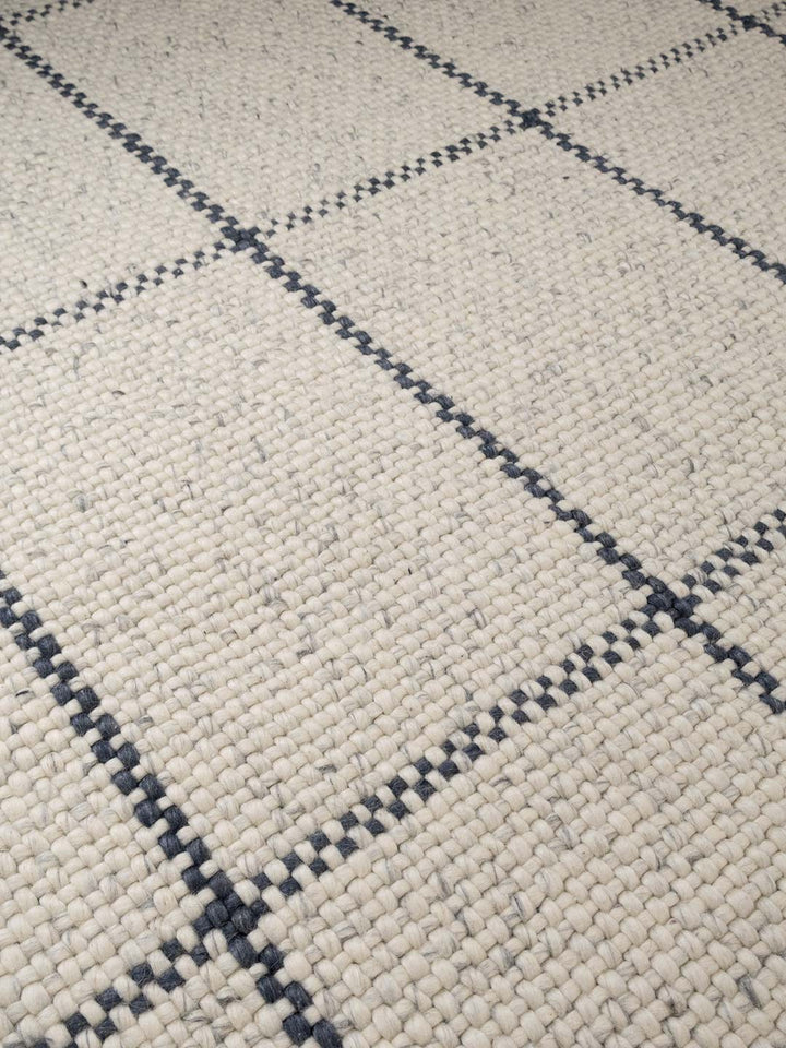 Close-up of a textured fabric with a diamond pattern in gray and black.