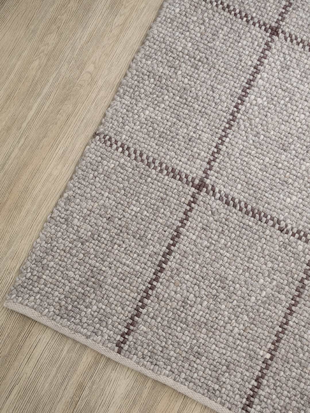 Gray checkered rug on a wooden floor