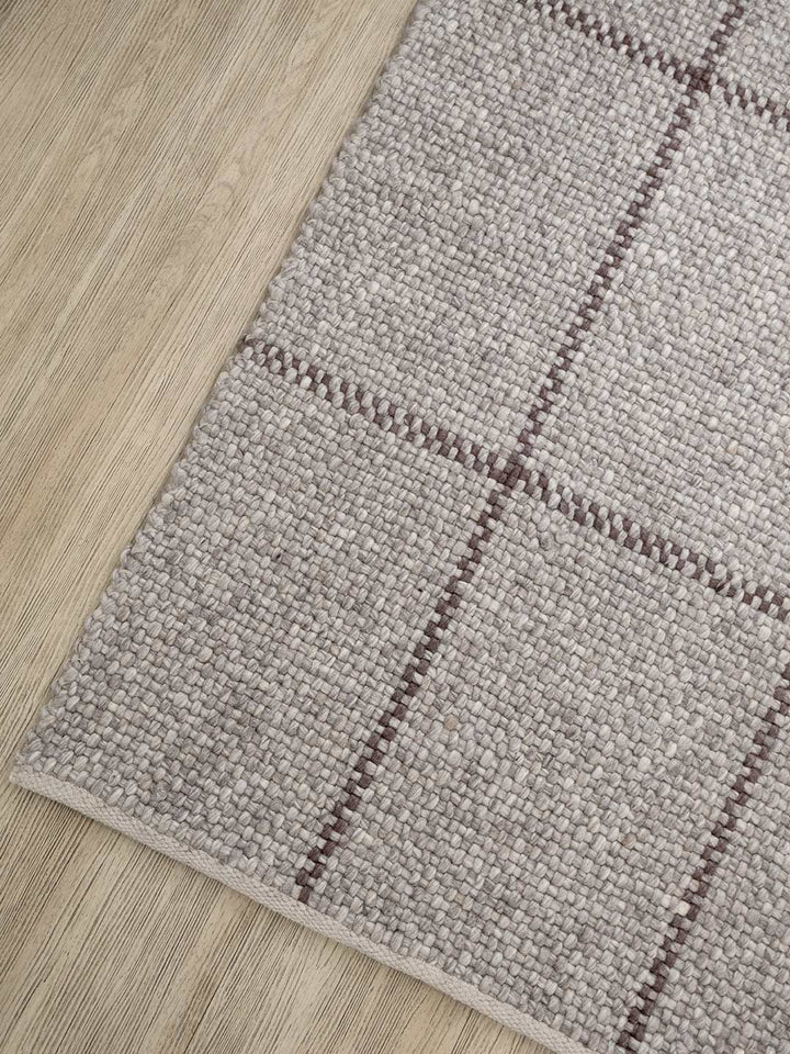 Gray checkered rug on a wooden floor