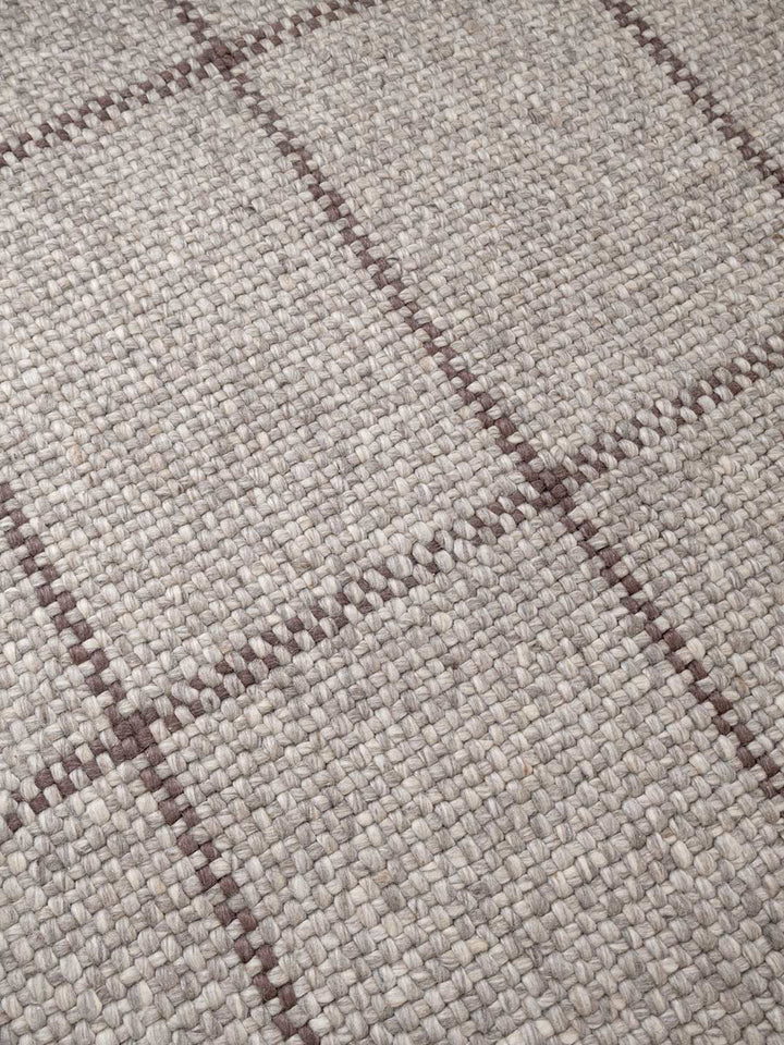 Close-up of a textured fabric with a checkered pattern in gray and brown.