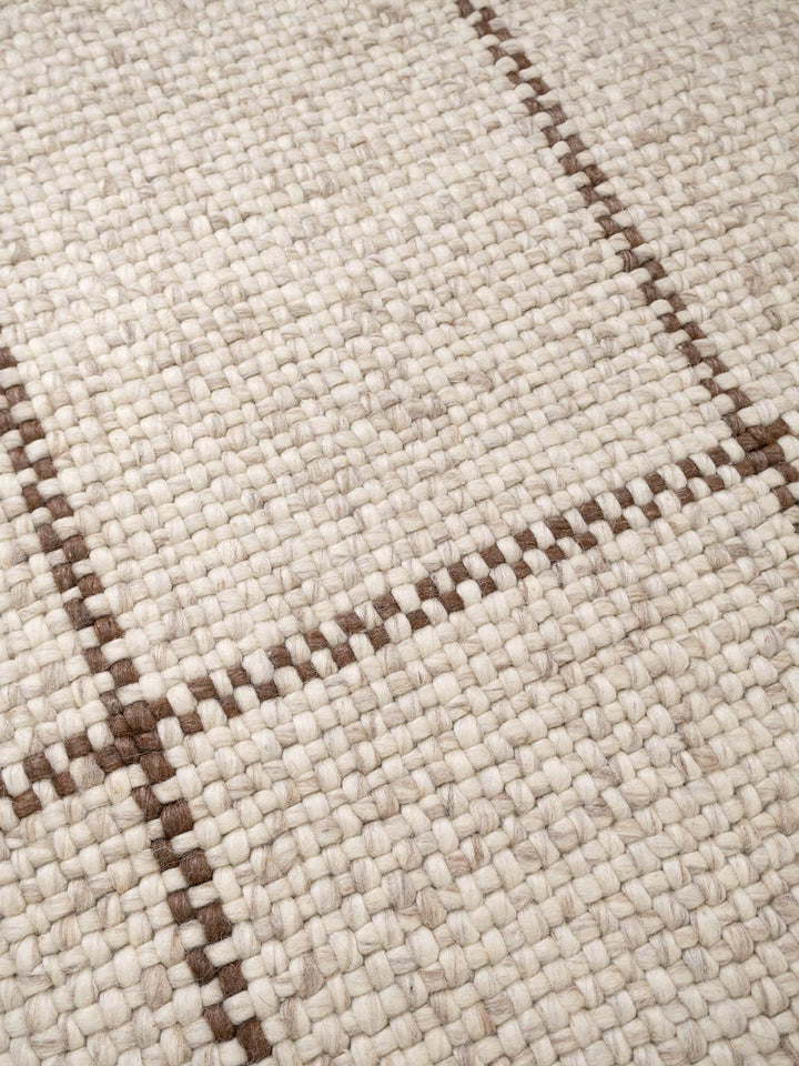 Close-up of a woven pattern on a beige fabric surface