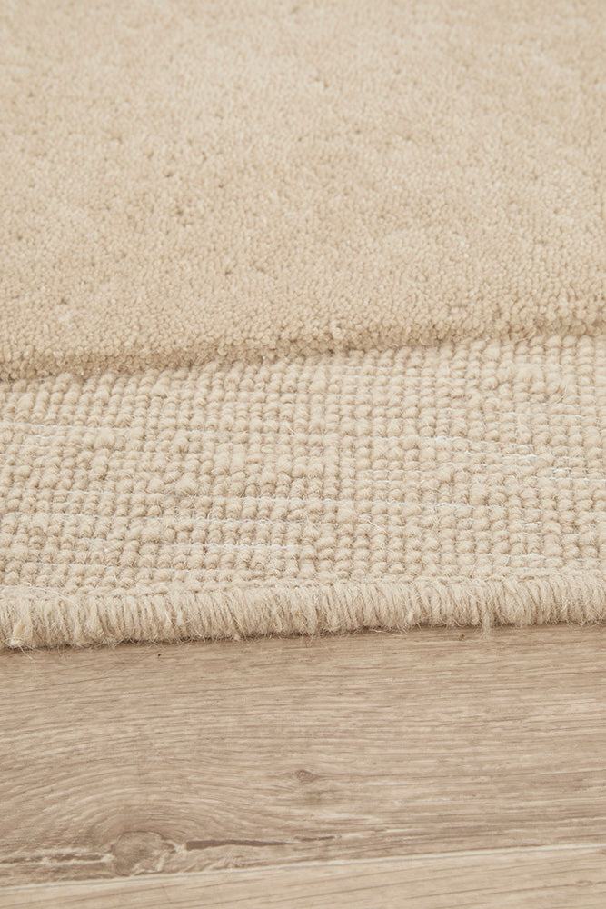 Close-up of a textured beige rug on a wooden floor