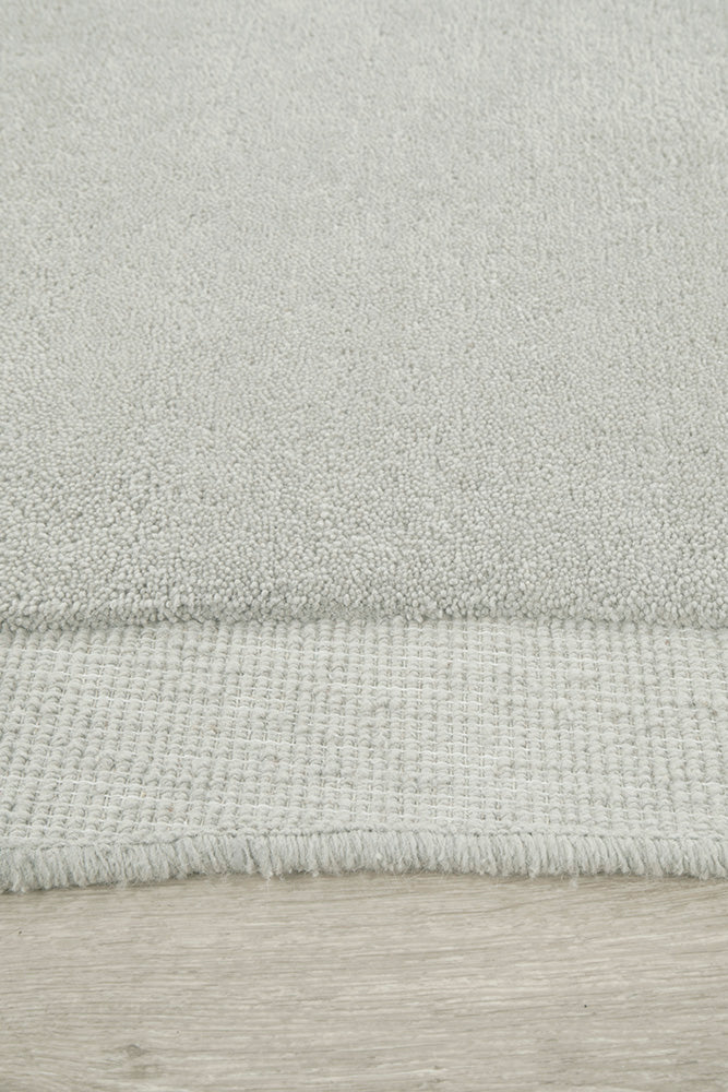 Close-up of a textured gray rug on a wooden floor