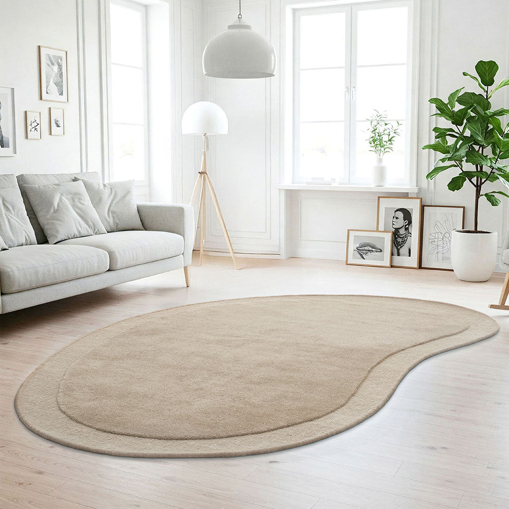 Beige rug on a wooden floor in a modern living room with a sofa and decor.