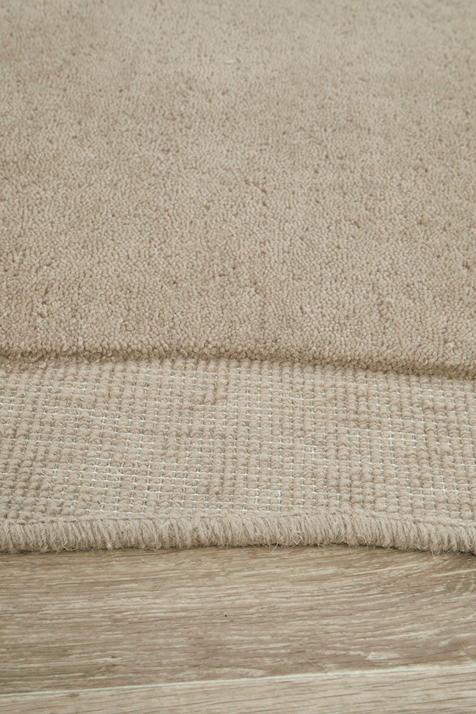 Close-up of a textured beige rug on a wooden floor