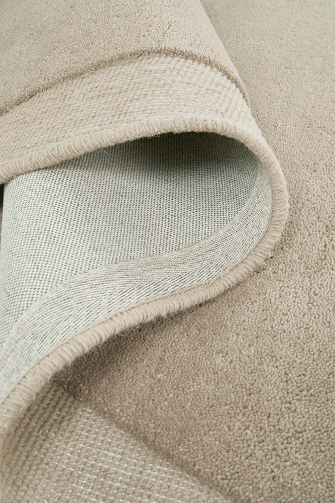 Close-up of a textured beige and light gray rug corner