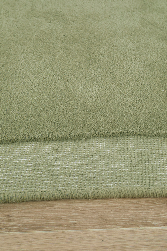 Close-up of a green rug on a wooden floor