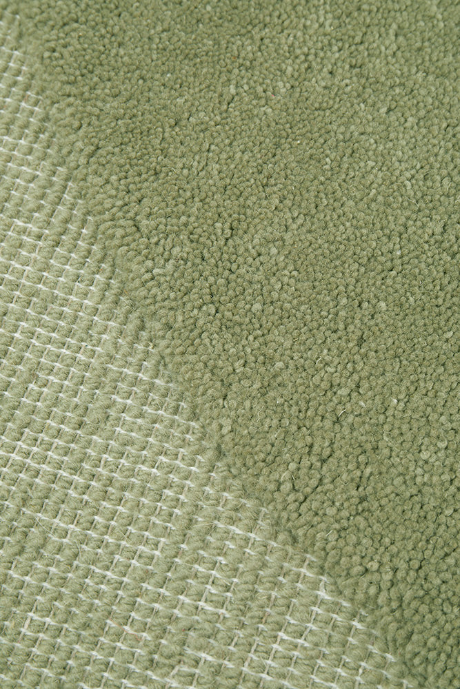 Close-up of green fabric texture in a floor rug
