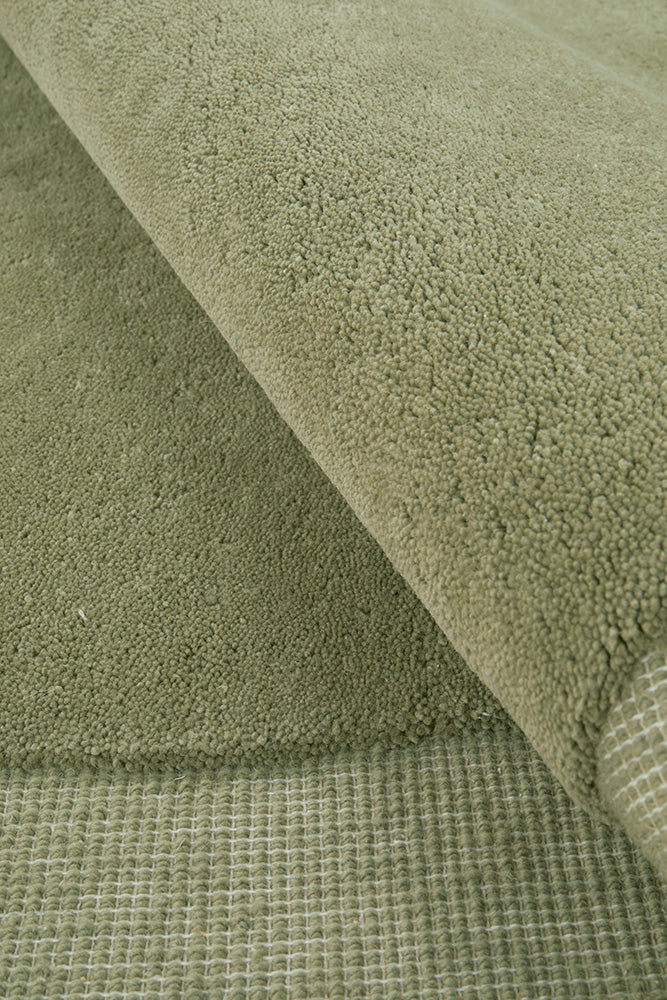 Close-up of green fabric with different textured rug
