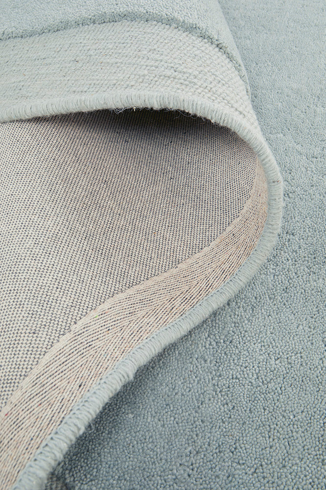 Close-up of a textured blue rug with a subtle pattern