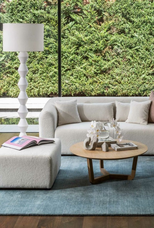 handmade wool rug in light blue with a lamp and linen couch