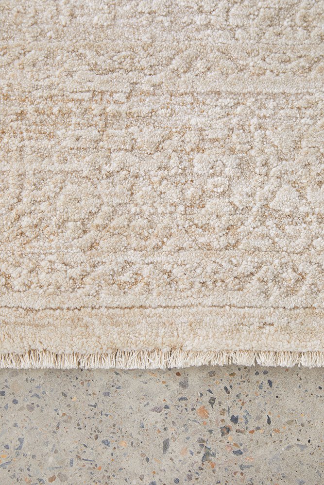 Textured beige rug with a concrete floor underneath