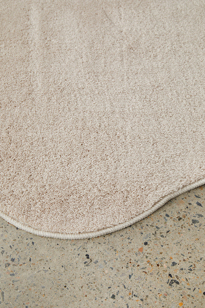 Beige bath mat on a concrete floor