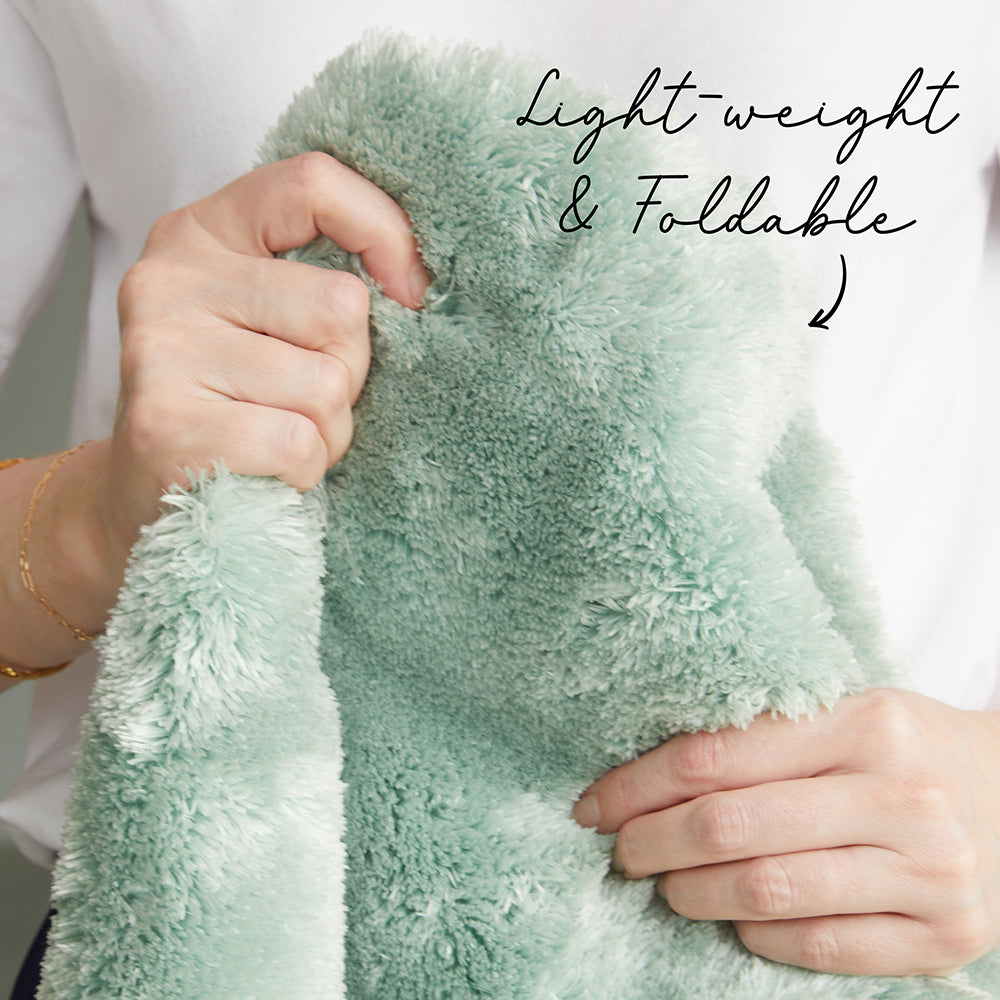Lightweight and foldable green towel held by hands with text overlay