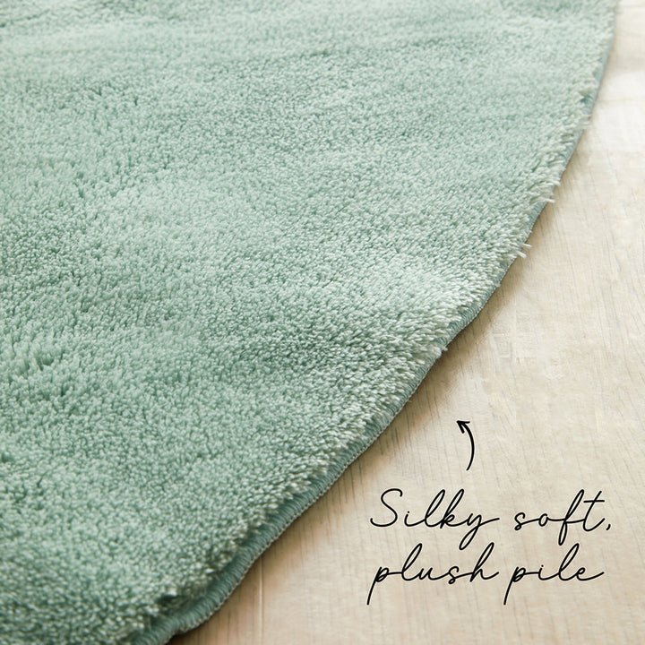 Green rug with plush pile texture on a wooden floor