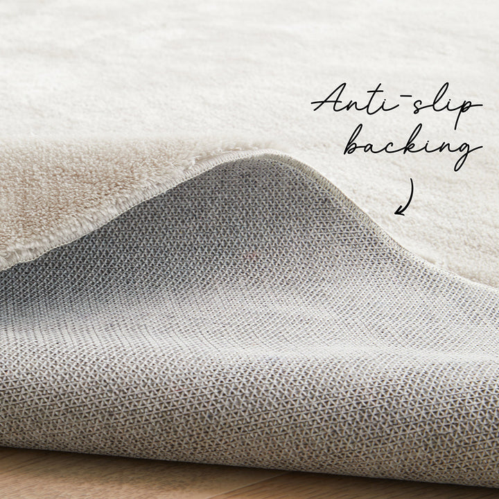 Close-up of a textured fabric with 'Anti-slip backing' text on a light background