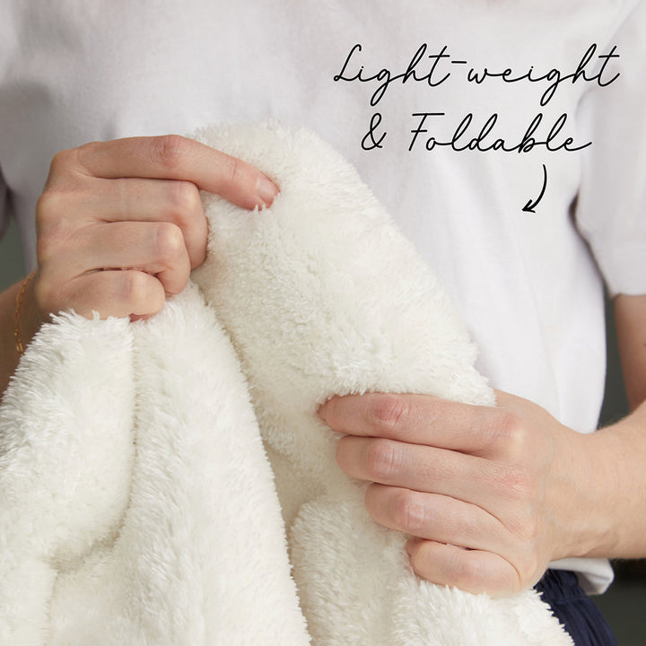 Person holding a light, fluffy white blanket with text 'Lightweight & Foldable' above.