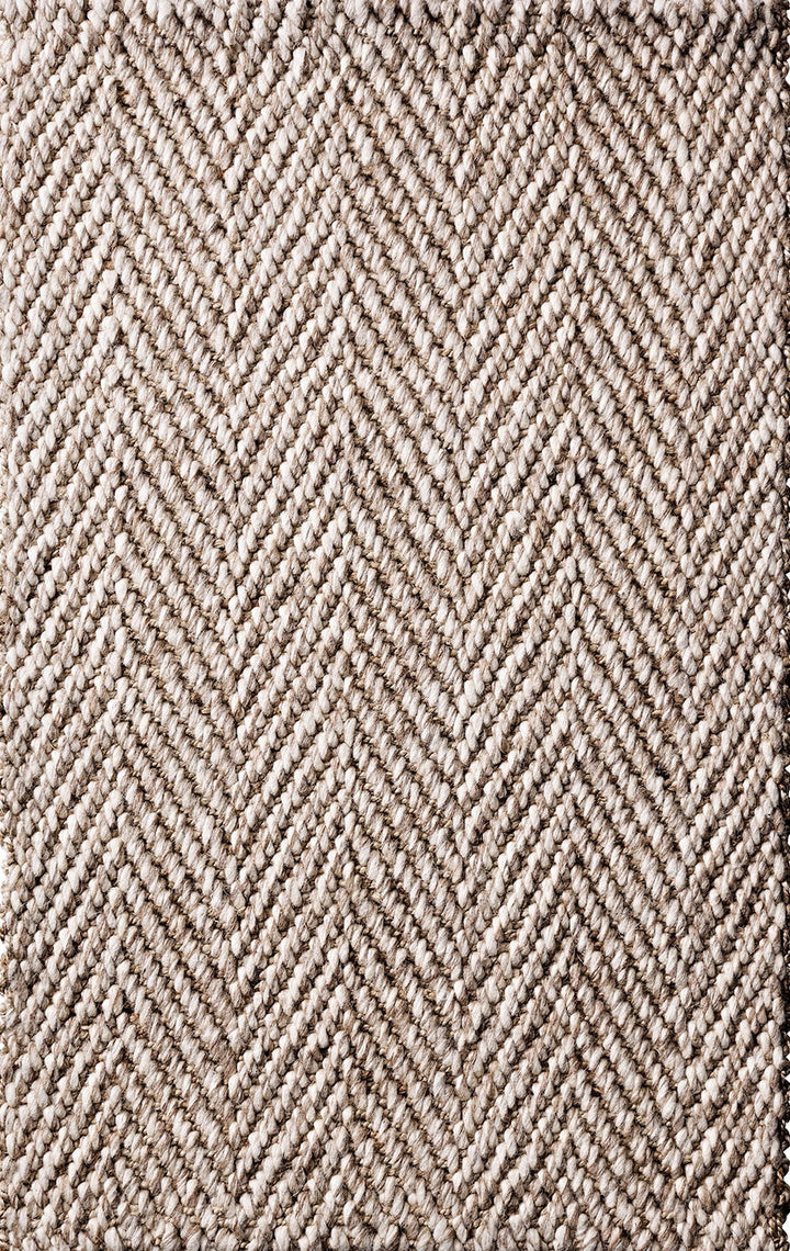 Textured rug with a herringbone pattern in beige and brown tones.