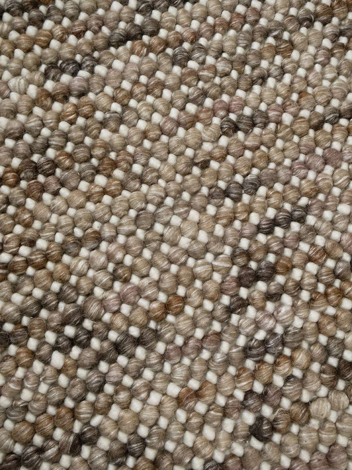 Close-up of a textured brown and beige carpet rug