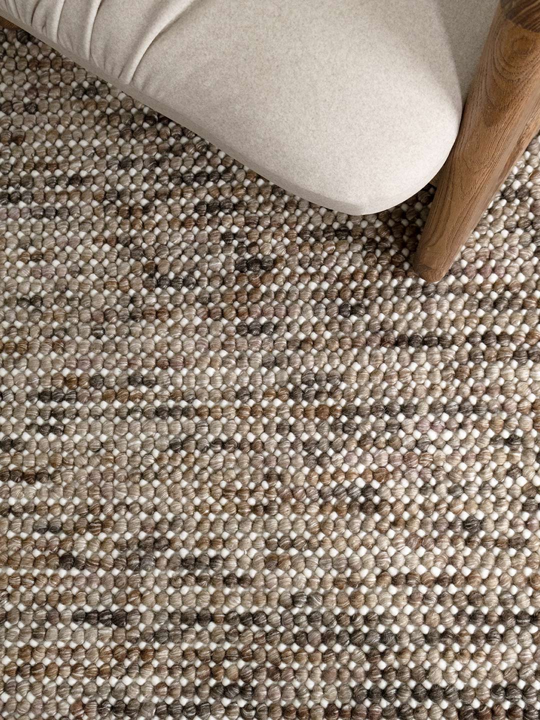 close up of a handmade wool textured rug in browns