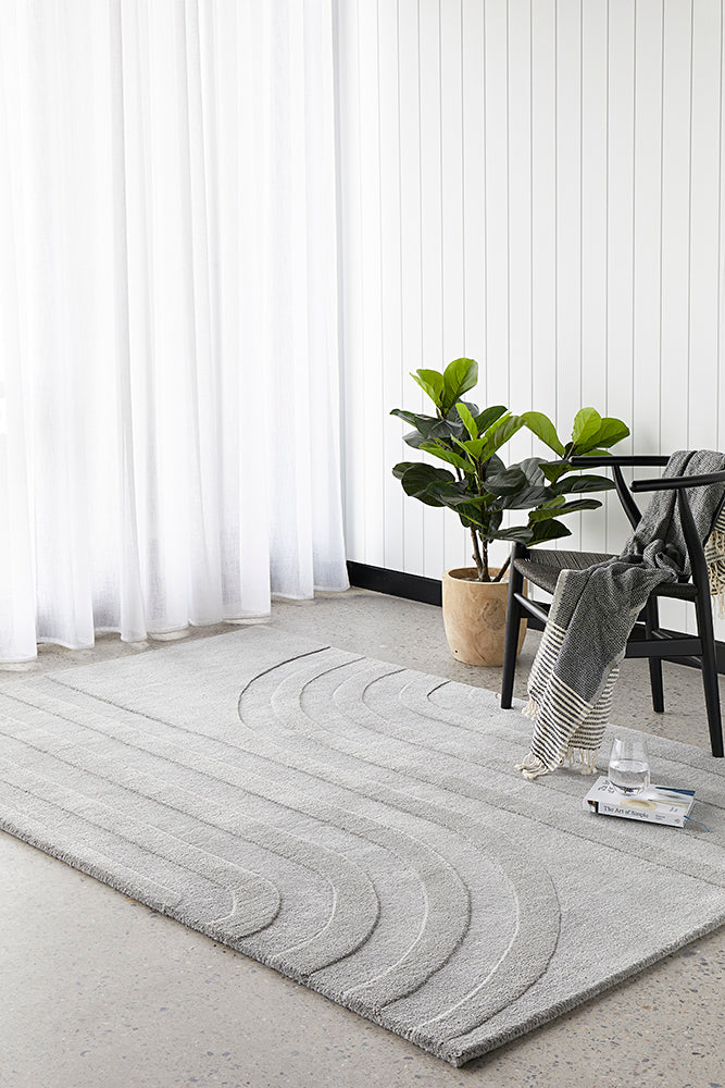 Modern living area featuring a neutral color palette and minimalist furniture, with a grey rug.