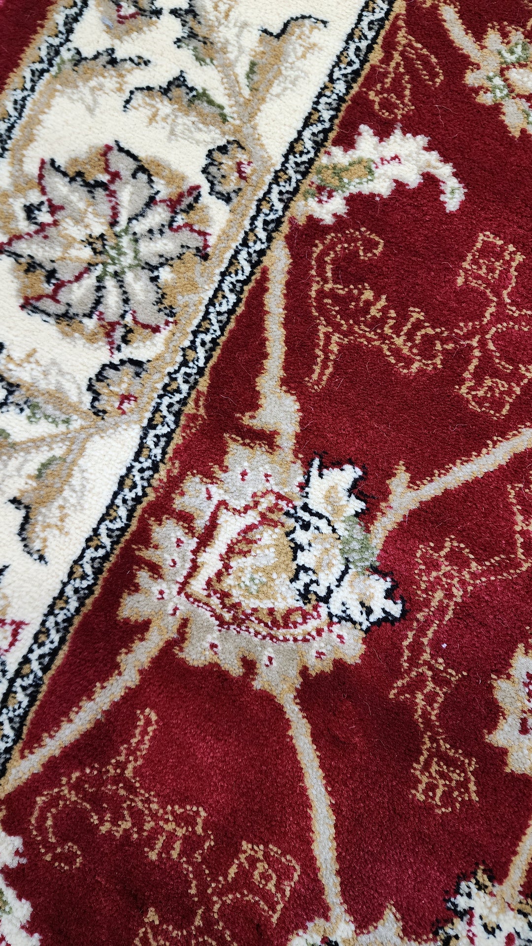 Close-up of a red and beige patterned runner with intricate designs.