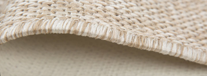Close-up of a textured beige fabric surface. The Block 2025.