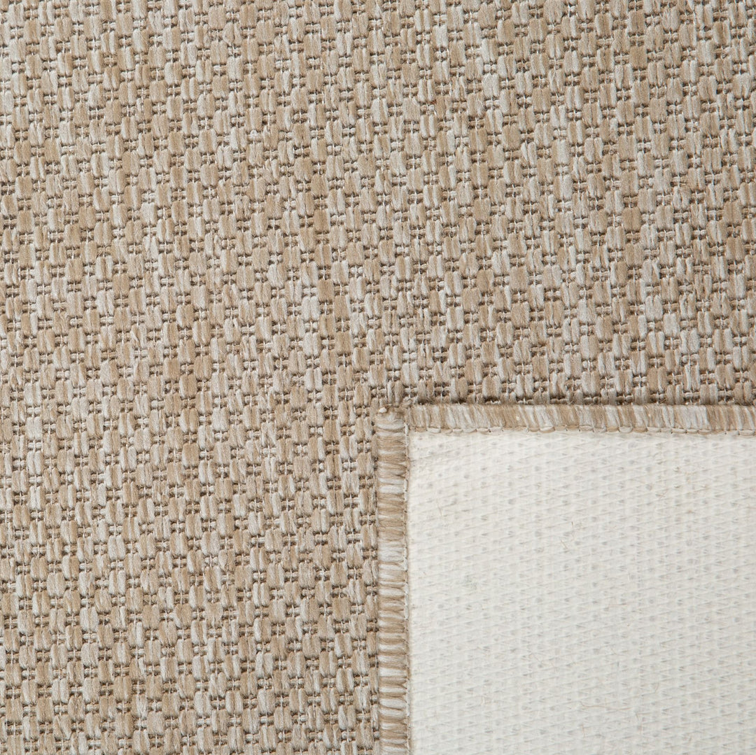Close-up of a textured beige and white rug corner