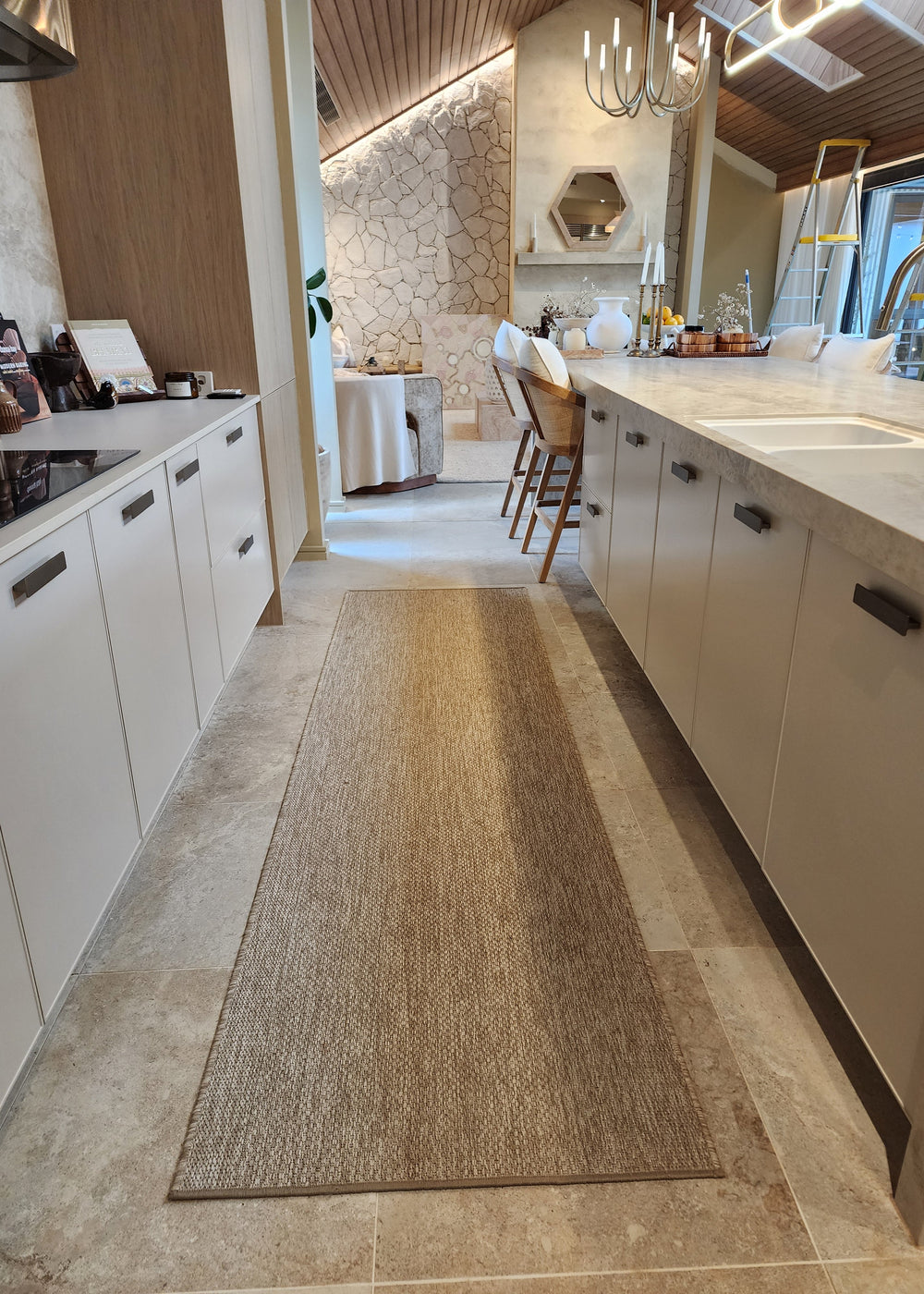 Kitchen with a woven runner rug on the floor. The Block 2025.