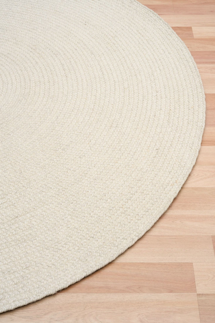 Round beige rug on a wooden floor