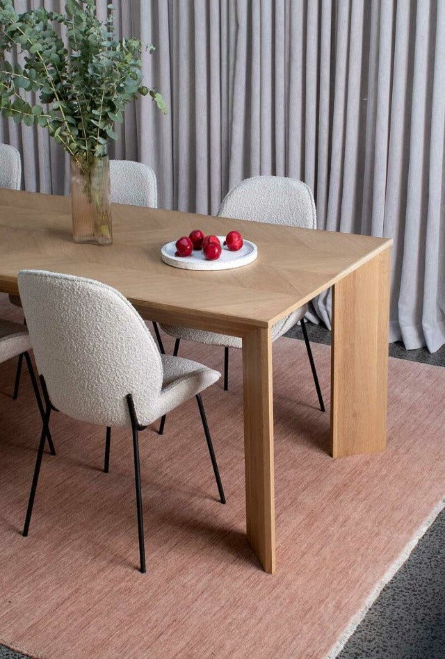 Salmon wool handmade rug under a dining table made from oak
