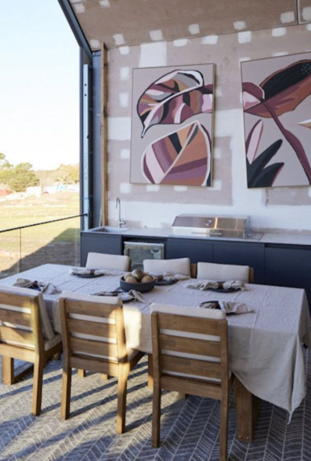 Outdoor dining area with outdoor rug under a nicely set dining table