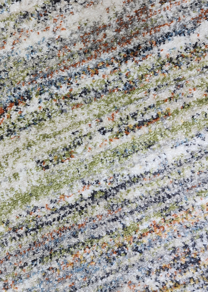 Close-up of a multicolored stone surface with gray, green, and orange hues.